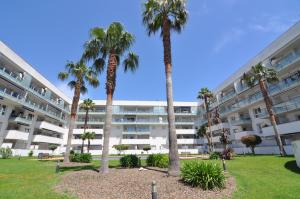een groot appartementencomplex met palmbomen in een park bij RNET - 402 - Porto Marina - Roses Costa Brava in Roses