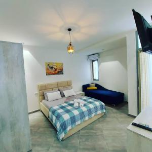 1 dormitorio con 1 cama y 1 sofá azul en Eden Hotel, en Shëngjin