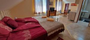 a bedroom with a large bed and a living room at Villa VértesKacsa in Vértesacsa
