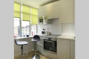 cocina con armarios blancos y fogones en Luxury 2-Bed Apartment In Central Brighton, en Brighton & Hove