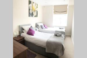 2 camas en una habitación de hotel con almohadas moradas en Luxury 2-Bed Apartment In Central Brighton, en Brighton & Hove