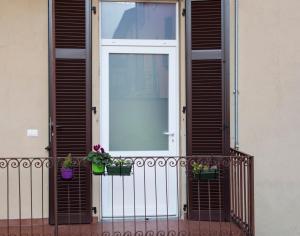 una porta su un balcone con due piante in vaso di Casa Molinari a Como