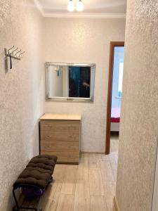 a bathroom with a wooden dresser and a mirror at Аппартаменты в самом центре Площадь-Вал in Chernihiv