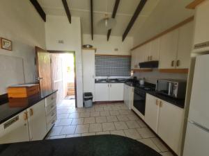 a large kitchen with white cabinets and a doorway at Allesreg Chalet E2 in Margate