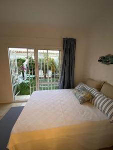 a bedroom with a bed and a sliding glass door at EL PARAISO GOLF Y PLAYA in Estepona