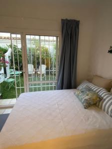 a bedroom with a large bed and a patio at EL PARAISO GOLF Y PLAYA in Estepona