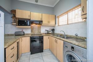a kitchen with a sink and a dishwasher at Waterfront 22 in Umdloti