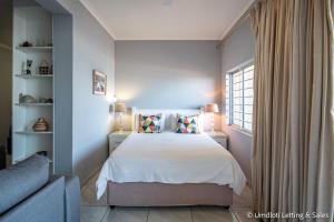 a bedroom with a bed and a couch and a window at Wavecrest in Umdloti +17 photos