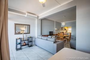 a living room with a couch and a dining room at Wavecrest in Umdloti