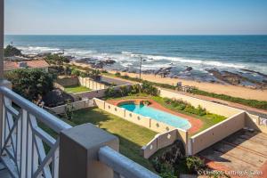 a view of a swimming pool and the beach at Wavecrest in Umdloti
