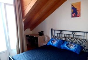 um quarto com uma cama com almofadas azuis em L'Angelo em Omegna
