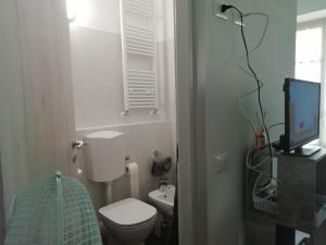 uma pequena casa de banho com um WC e uma televisão em L'Angelo em Omegna