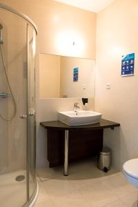 uma casa de banho com um lavatório e um chuveiro em Hotel Police em Police Mostowe
