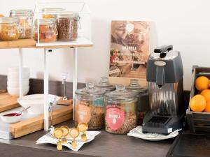 a kitchen counter with jars of food and a blender at Novotel Charleroi Centre in Charleroi