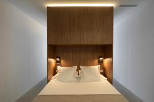 Dau Studios في فالنسيا: غرفة نوم مع سرير مع اللوح الأمامي الخشبي