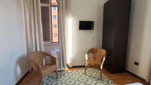 2 Stühle und ein Teppich in einem Zimmer mit Fenster in der Unterkunft Colosseo Kokedama rooms in Rom