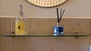two bottles on a glass shelf in a bathroom at Colosseo Kokedama rooms in Rome