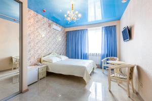 a bedroom with a bed and a blue ceiling at Hotel Premier in Kamianske
