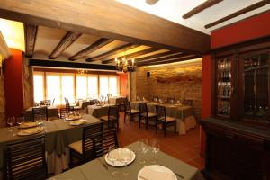 a restaurant with tables and chairs in a room at Hotel del Sitjar in Calaceite