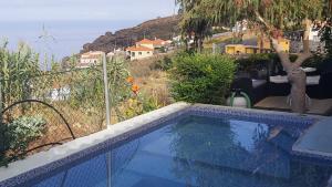 a swimming pool with a view of the ocean at Canto da Manu in Estreito da Calheta