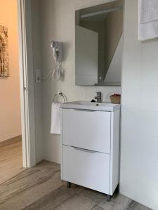 una cucina bianca con lavandino e specchio di Apartamento Los Arcos a Llanes