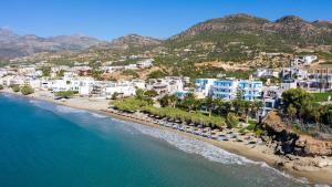 una vista aérea de una playa con sillas y edificios en Artemis en Makry Gialos