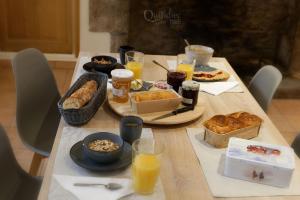 uma mesa com alimentos e bebidas para o pequeno almoço em Manoir Pors Braz B&B em Commana