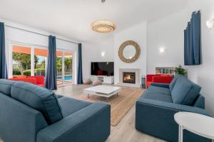 - un salon avec deux canapés bleus et une cheminée dans l'établissement Beach Villa - oceanfront villa Martinhal, à Sagres