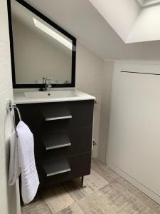 un bagno con lavandino e specchio di Apartamento Los Arcos a Llanes Altre 19 foto