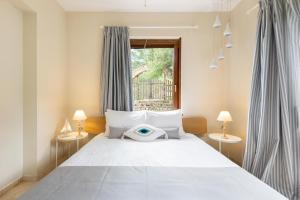 オルモス・パナギアスにある#FLH - Villa Louiseのベッドルーム(白い大型ベッド、ランプ2つ付)