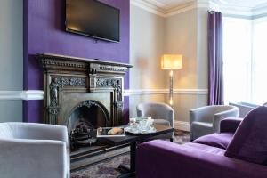 a living room with a fireplace and purple walls at The County Hotel in Llandudno