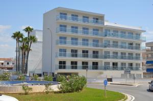 a white building with palm trees in front of it at Hotel Sant Jordi in Playa de Palma