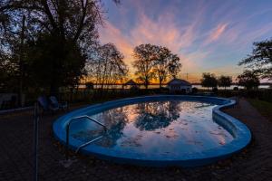 a small pool in a yard with a sunset in the background at Gîte Saint-Laurent in Trois-Rivières