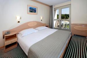 a bedroom with a large bed and a window at Hotel Istra Plava Laguna in Poreč