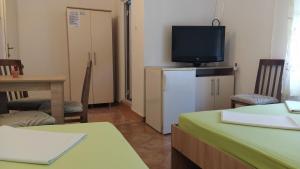 a room with a tv and a refrigerator and a table at Apartmani Nino in Star Dojran