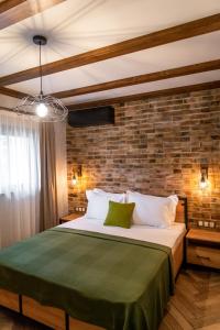 ein Schlafzimmer mit einem großen Bett mit Ziegelwand in der Unterkunft Hotel Hunters House in Ezerets
