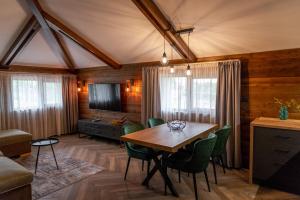 a dining room with a table and green chairs at Hotel Hunters House in Ezerets