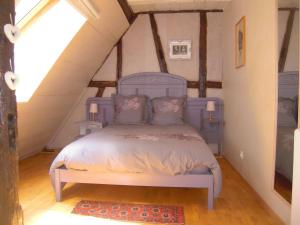 a bedroom with a blue bed in a attic at Appartement Le Chez Soi Riquewihr in Riquewihr