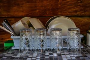 a table with three glasses and a plate and utensils at Place near beach in Pērkone +49 photos