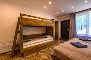 a bedroom with two bunk beds and a window at Place near beach in Pērkone