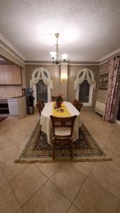 a dining room with a table and chairs on a rug at "Kasneci Residence" Countryside Villa with a pool in Tirana