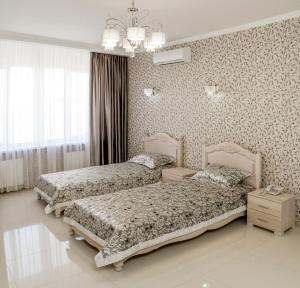 a bedroom with two beds and a chandelier at Hotel Premier in Kamianske