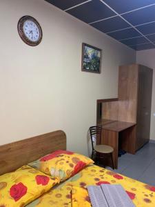 a bedroom with a bed and a clock on the wall at Ryabinka Hotel in Cheboksary
