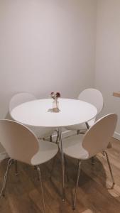 a white table with four chairs and a vase on it at Heart Of Aberdeen City Centre 3 Bedrooms Apartment in Aberdeen