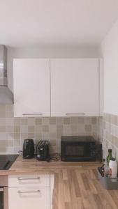 a kitchen with white cabinets and a microwave at Heart Of Aberdeen City Centre 3 Bedrooms Apartment in Aberdeen