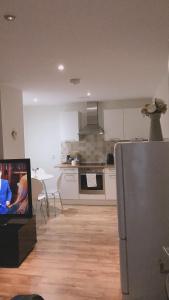 eine Küche mit einem Kühlschrank aus Edelstahl und einem Tisch in der Unterkunft Heart Of Aberdeen City Centre 3 Bedrooms Apartment in Aberdeen