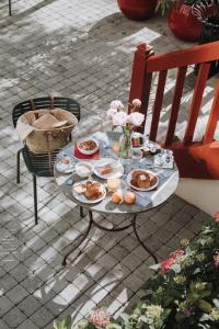 una mesa con platos de comida y flores. en Hotel Saint Julien en Biarritz