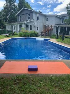 a swimming pool in front of a house at Auberge Clos-Joli in Morin Heights