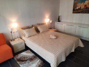 1 dormitorio con 1 cama y 1 silla naranja en Yoo Bulgaria Apartments -c306 en Obzor