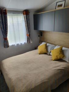 a bedroom with a large bed with yellow pillows at Devon holiday in Goodrington